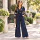 Eleganblomstret Jumpsuit med V-utringning, Vidbeinte Bukser, Midjebånd og Kruslete 3/4-ermer